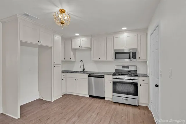 a kitchen with stainless steel appliances granite countertop a stove a sink and a refrigerator