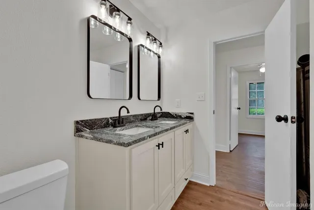 a bathroom with a granite countertop sink and a mirror