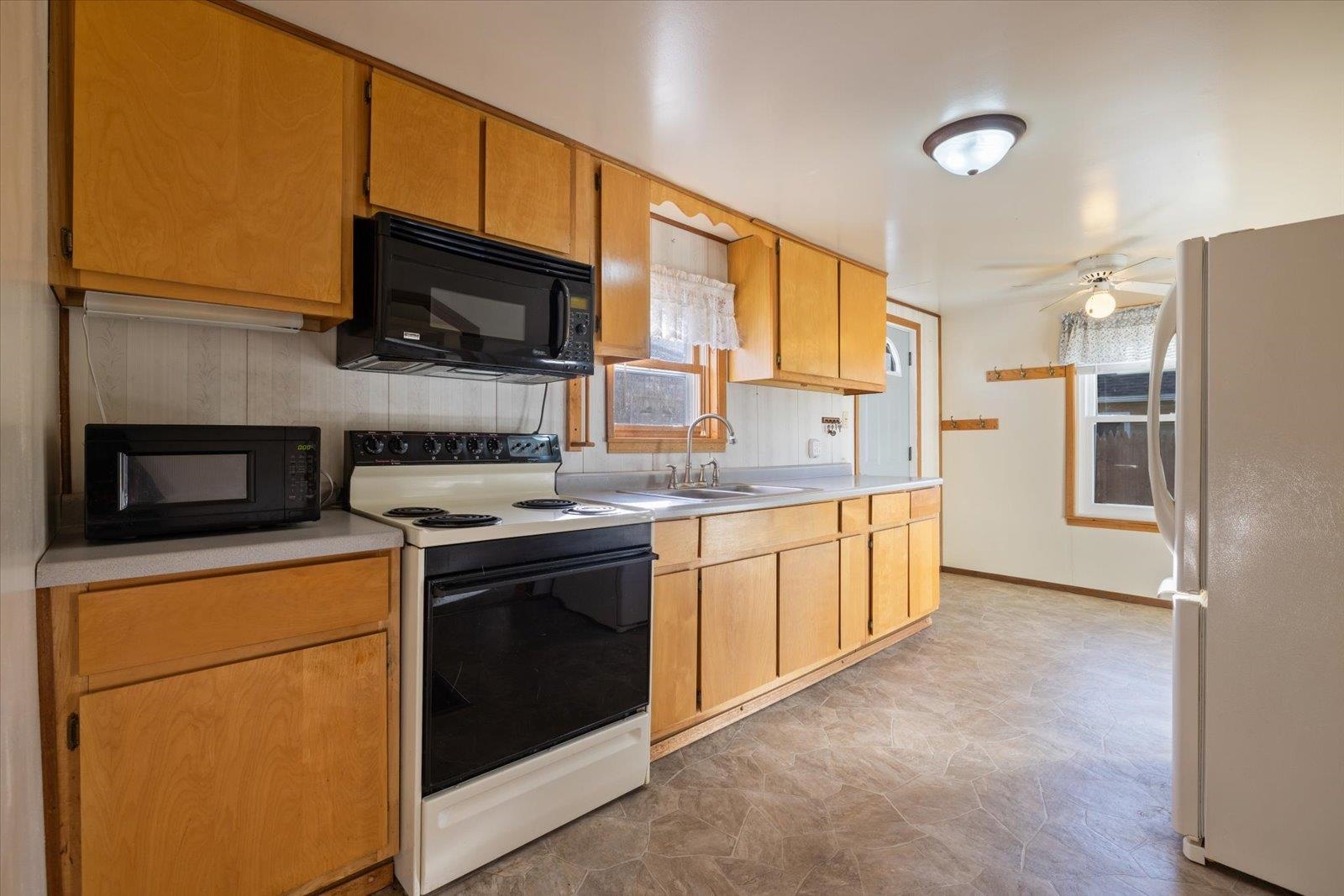 2120 Kelly Avenue Cloquet, MN 55720 - Photo 15 of 38 Kitchen featuring electric range oven, freestanding refrigerator, healthy amount of natural light, and black microwave