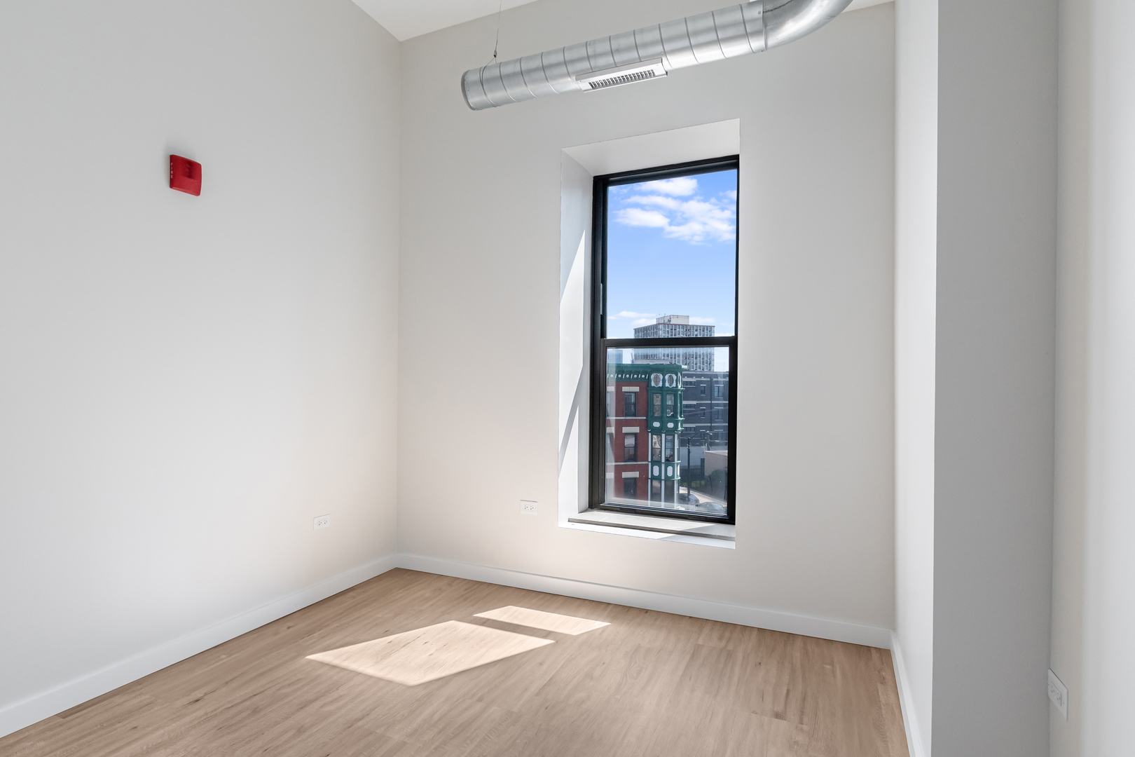 805 North Milwaukee Avenue, Unit 2S Chicago, IL 60642 - Photo 17 of 29 an empty room with wooden floor and windows