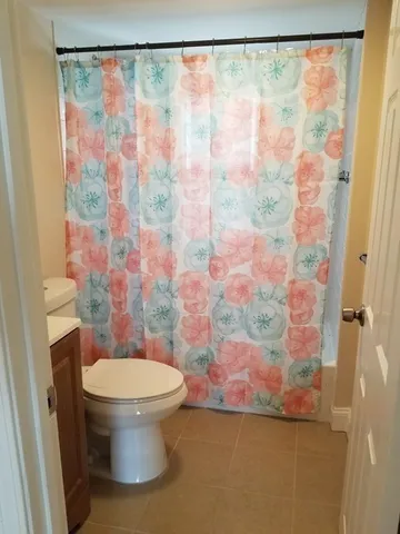 a white toilet sitting next to a shower curtain