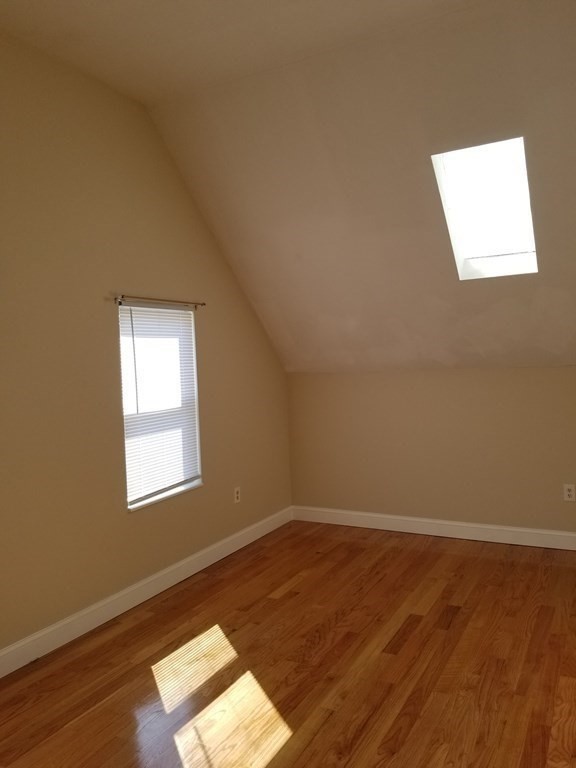 593 Park Street, Unit 3 Boston, MA 02124 - Photo 17 of 29 an empty room with wooden floor and windows
