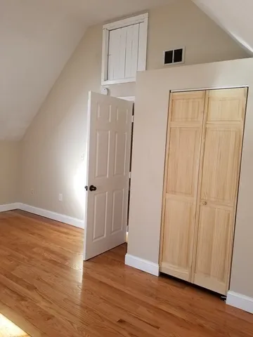 an empty room with wooden floor and window