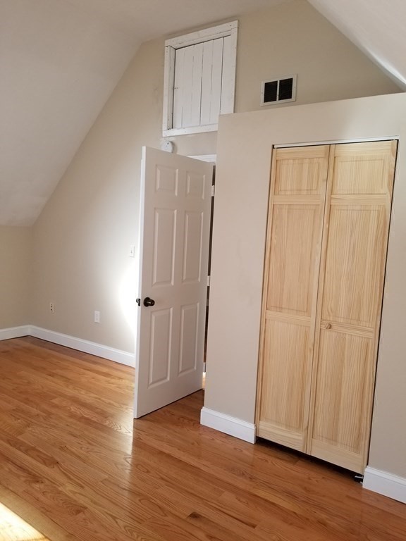 593 Park Street, Unit 3 Boston, MA 02124 - Photo 22 of 29 an empty room with wooden floor and window
