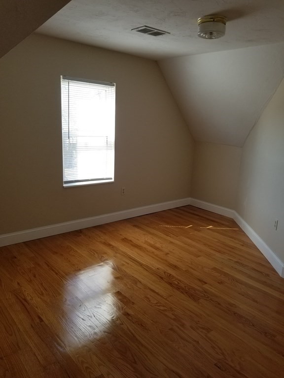 593 Park Street, Unit 3 Boston, MA 02124 - Photo 23 of 29 an empty room with wooden floor and windows