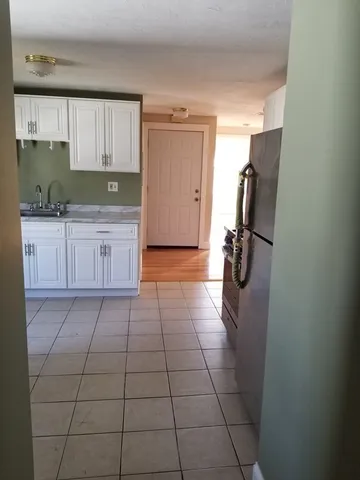 a kitchen with a sink a refrigerator and cabinets