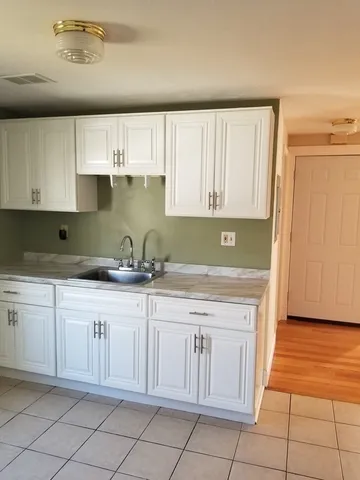 a kitchen with granite countertop a sink and cabinets