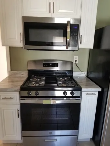 a stove top oven sitting inside of a kitchen