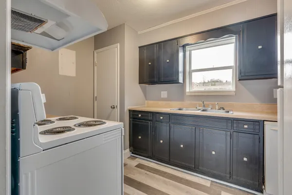 a kitchen with sink a refrigerator and cabinets