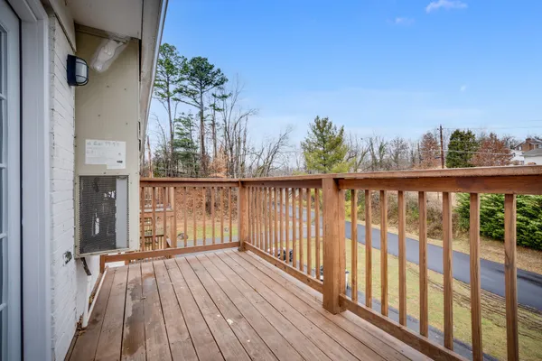 a view of a balcony with wooden floor and fence