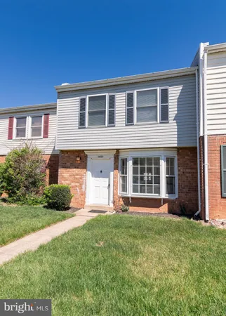 a front view of a house with yard and green space