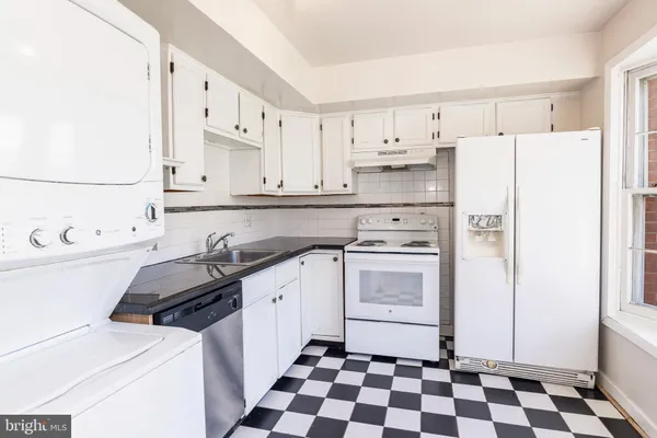 a kitchen with white cabinets and white appliances