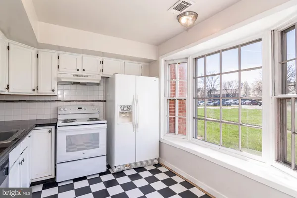 a kitchen with a stove a refrigerator and a window