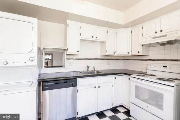 a kitchen with granite countertop white cabinets and white appliances