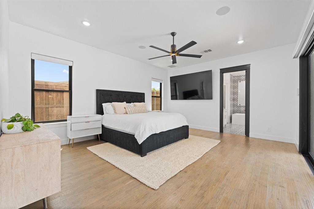 613 Wildcat Way Kennedale, TX 76060 - Photo 17 of 40 a spacious bedroom with a large bed a chandelier and a window