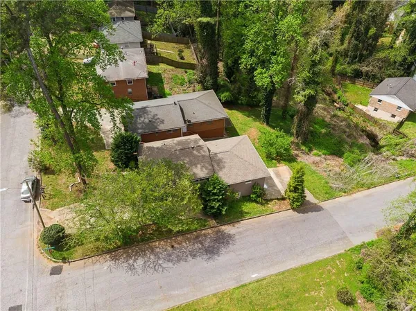 an aerial view of a house with swimming pool and large trees