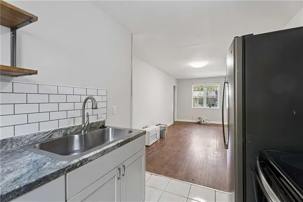 a kitchen with a sink a refrigerator and cabinets