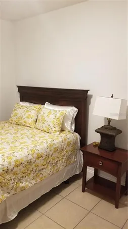 a bedroom with a bed and a potted plant