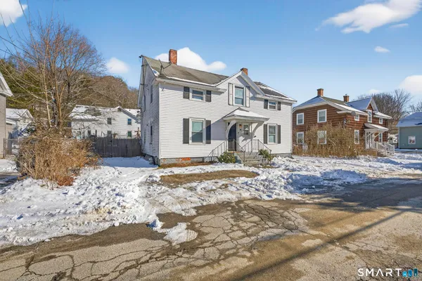 a front view of a house with a yard covered in snow