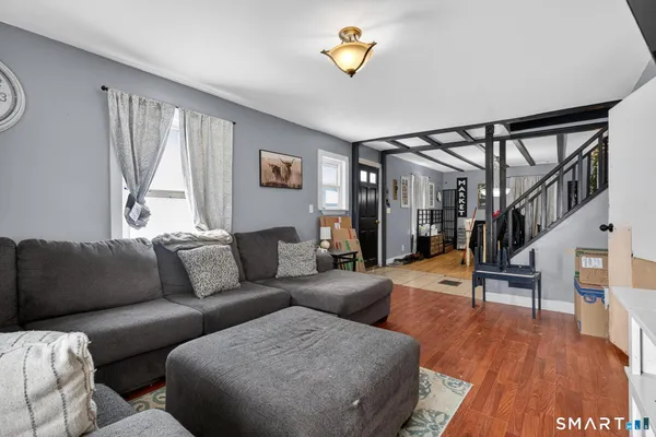a living room with furniture and a wooden floor