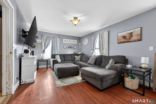 a living room with furniture and a wooden floor