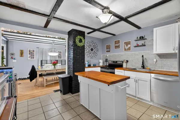 a kitchen with stainless steel appliances kitchen island granite countertop a table and chairs