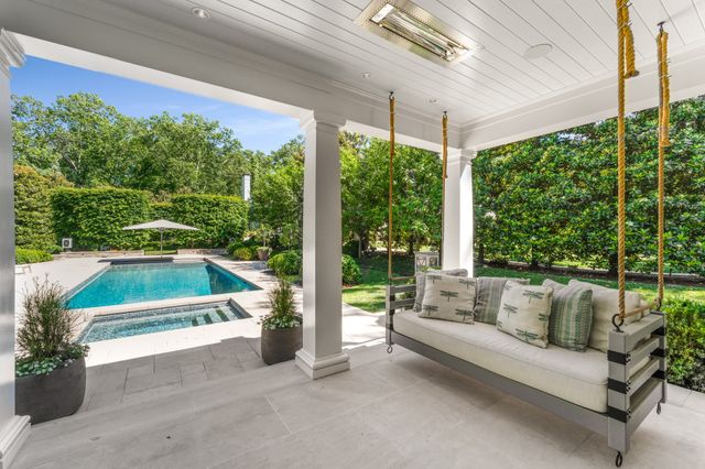 a living room with furniture large window and wooden floor