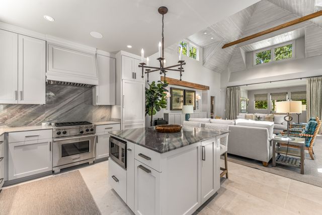 a living room with patio furniture and a chandelier