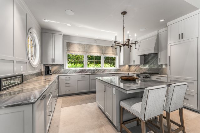 a living room with furniture fireplace and large windows