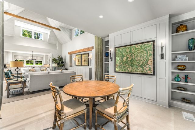 a kitchen with stainless steel appliances granite countertop a stove top oven a sink a dining table and chairs