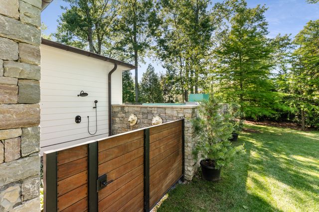 a kitchen with stainless steel appliances granite countertop a stove top oven a sink dishwasher a dining table and chairs with wooden floor