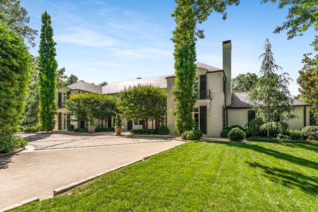 an aerial view of a house with a yard and large trees