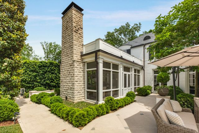 a view of a white house with a big yard and large trees