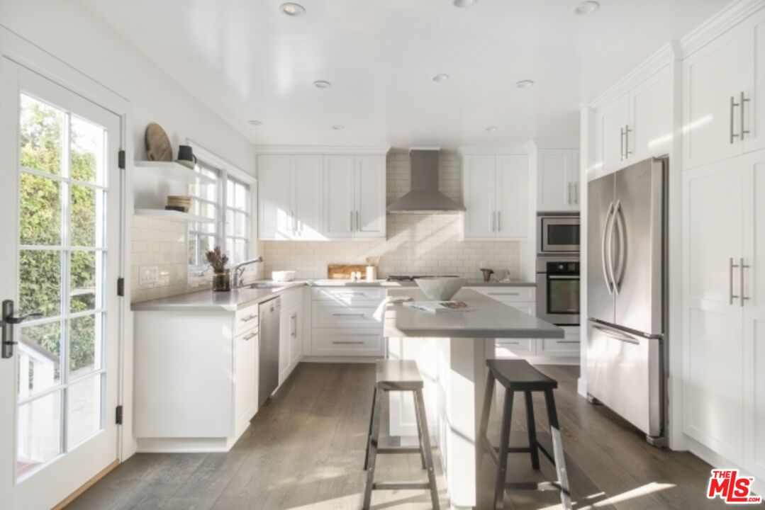 6607 Moore Drive Los Angeles, CA 90048 - Photo 13 of 42 a kitchen with white cabinets and stainless steel appliances