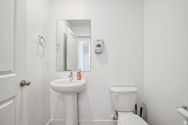 2097 North Ostler Peak Road, Unit 115 Heber City, UT 84032 - Photo 32 of 33 Powder room featuring a pedestal sink with a chrome faucet, a rectangular wall-mounted mirror, and a toilet