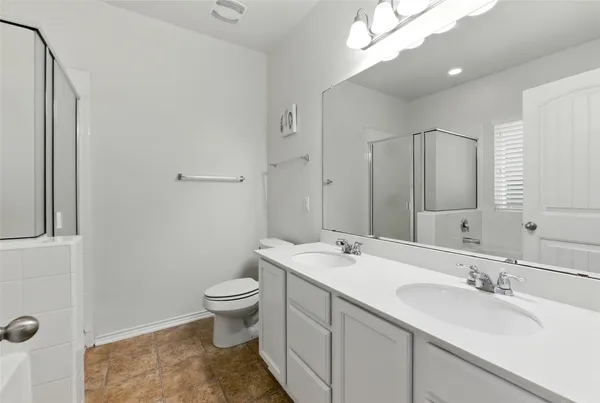 a bathroom with a double vanity sink mirror and toilet