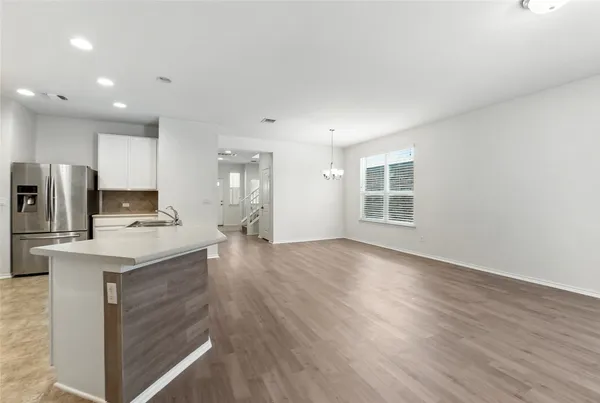 a view of kitchen with sink microwave refrigerator and cabinets