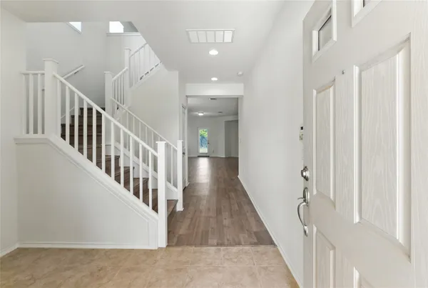 a view of a hallway with wooden floor and entryway
