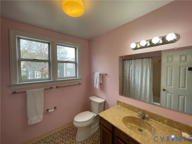 a bathroom with a granite countertop sink toilet and mirror