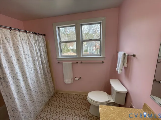 a white toilet sitting next to a shower curtain
