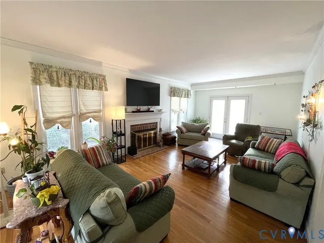 a living room with furniture flat screen tv and a large window