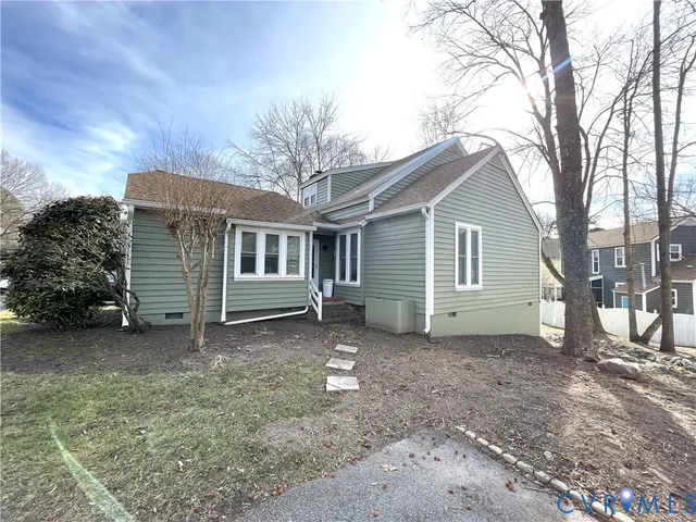 a view of a house with a yard and large tree