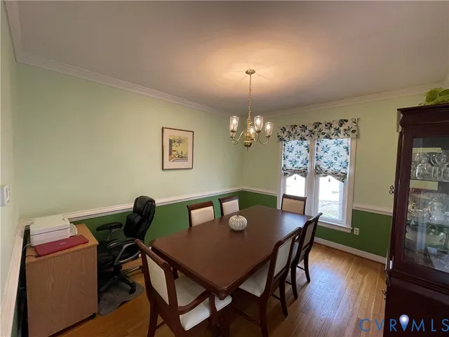 a view of a dining room with furniture a chandelier and wooden floor