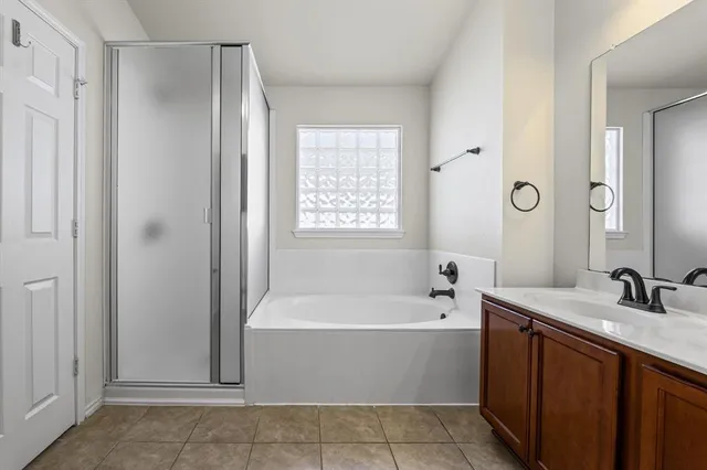a bathroom with a tub sink double vanity granite and mirror