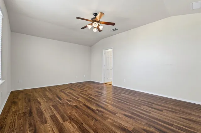a view of an empty room with wooden floor