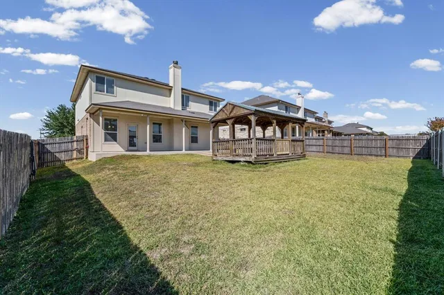 a view of a house with backyard and porch