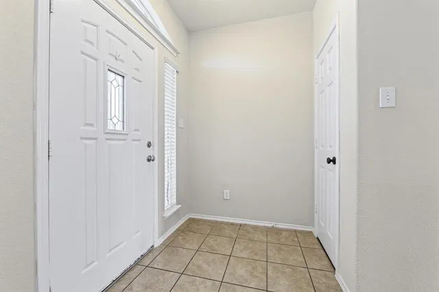 an empty room with windows fireplace and a window