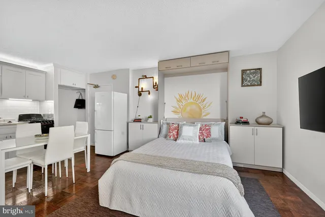 a bedroom with a bed a couch and dresser