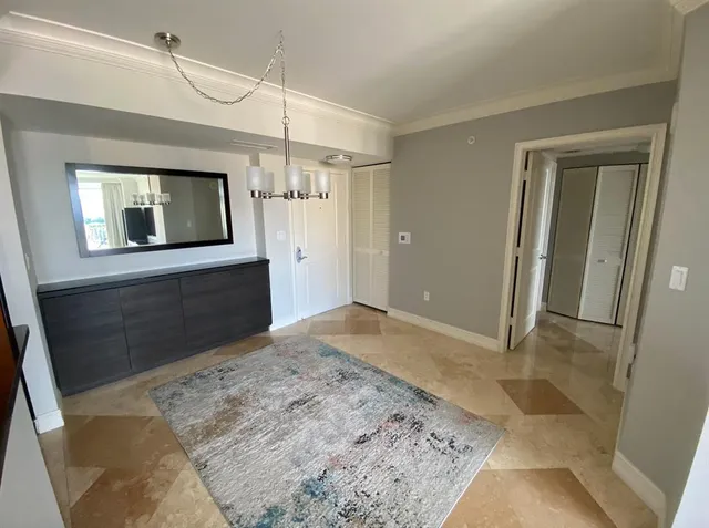 a living room with furniture a flat screen tv and a floor to ceiling window