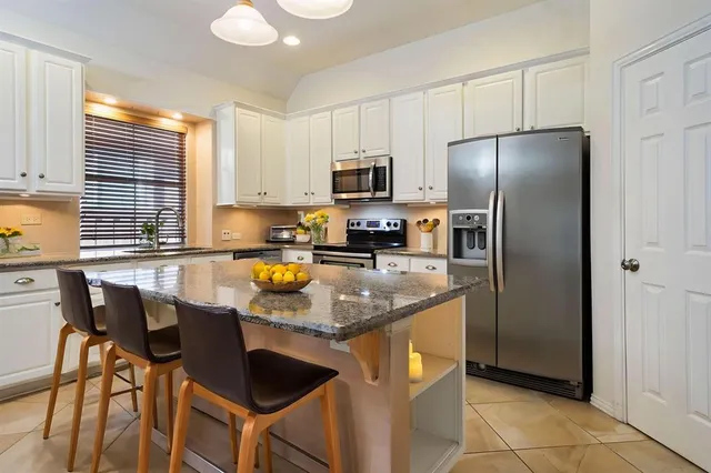 a kitchen with granite countertop a counter space appliances and cabinets